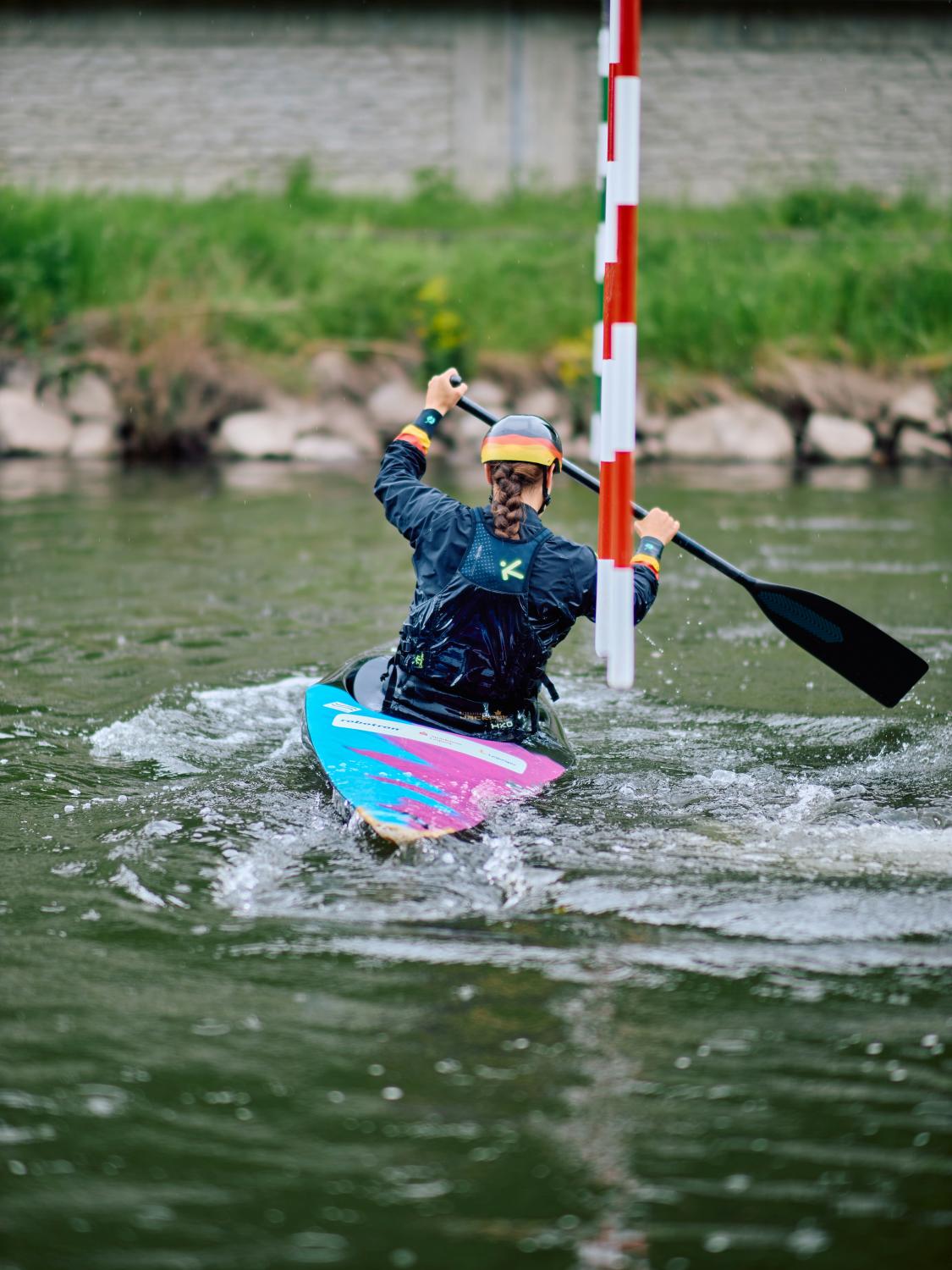 Kayaker paddling through a slalom course