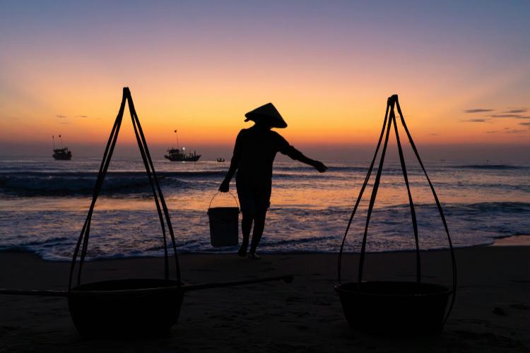 Figure silhouetted against a beach sunset